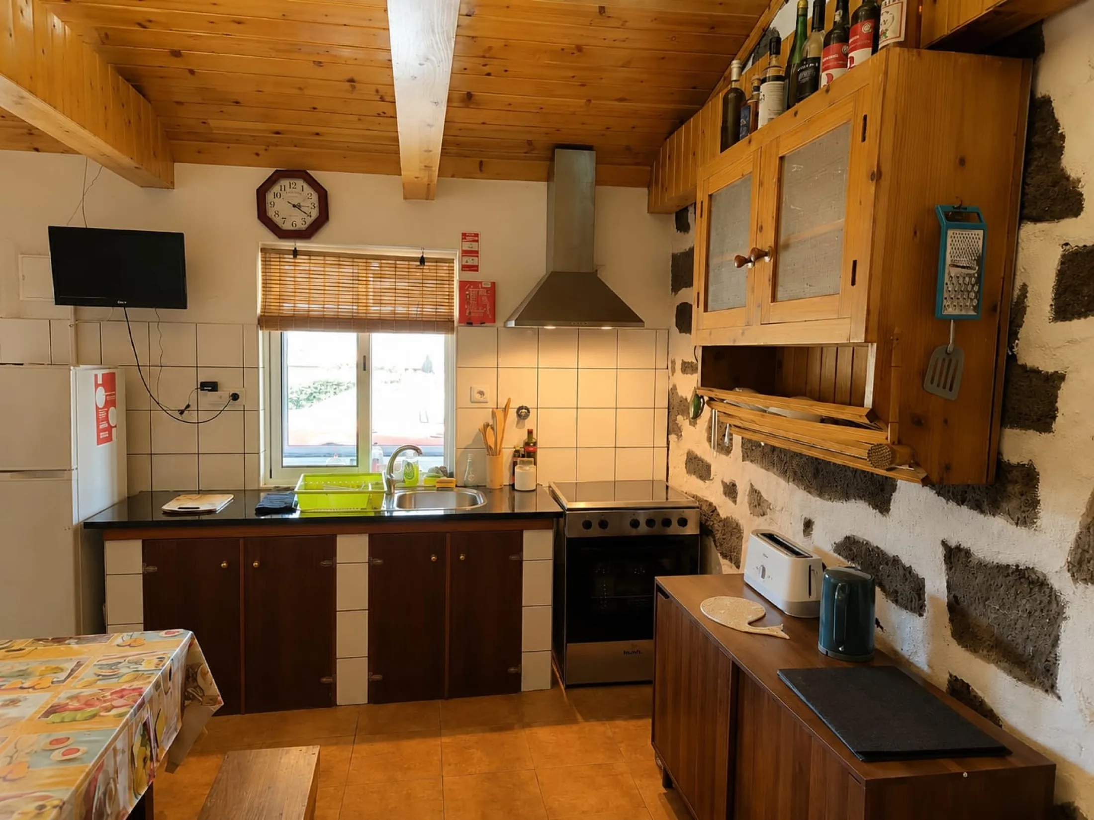 Cozinha acolhedora com parede original em pedra vulcânica