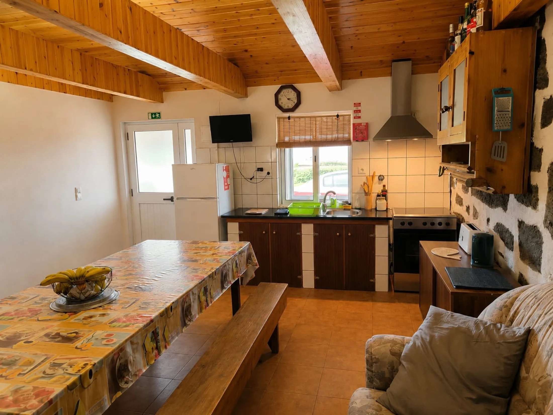 Cozinha equipada com paredes de pedra vulcânica e teto em madeira