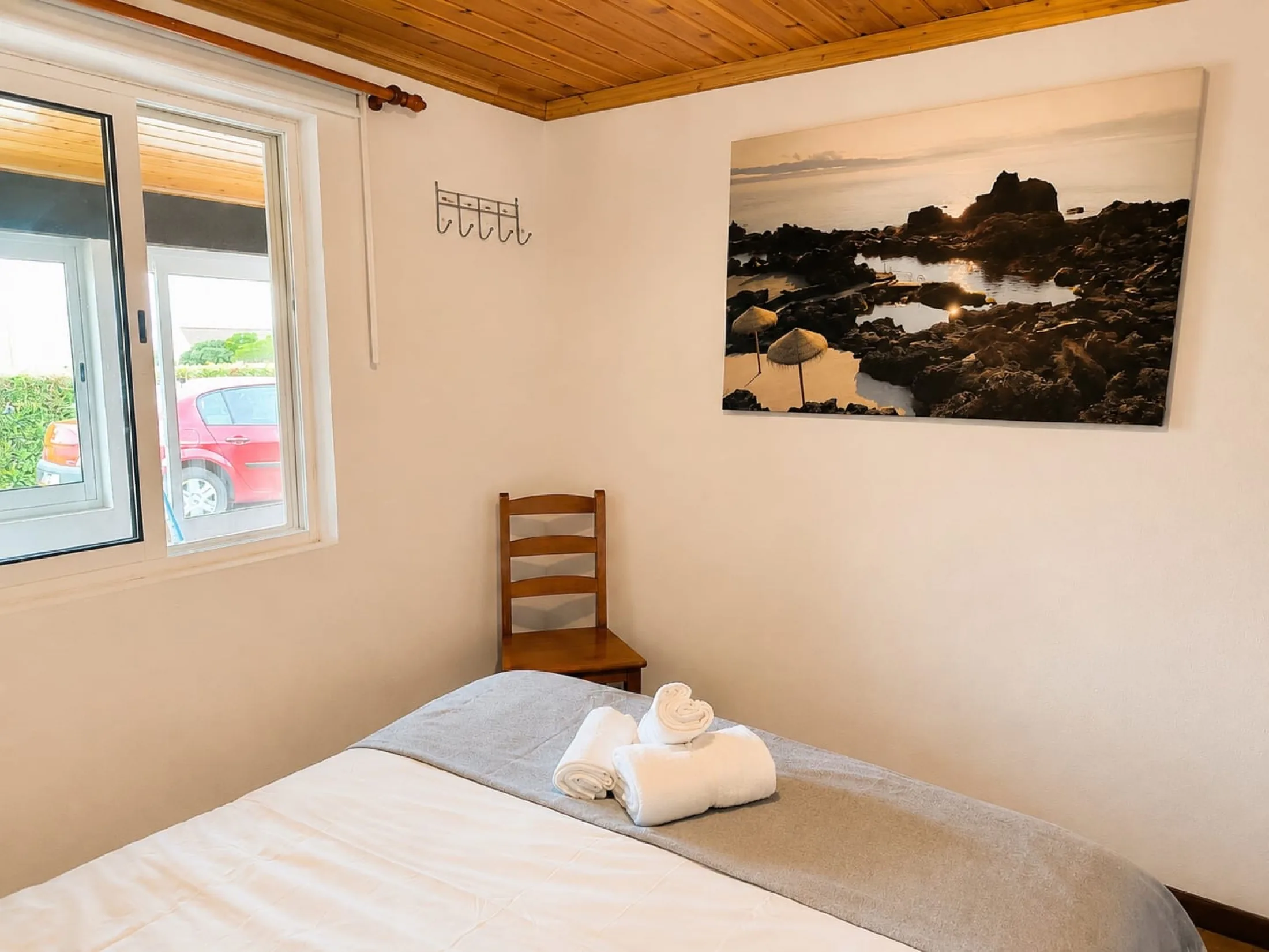 Quarto de casal com fotografia das piscinas naturais