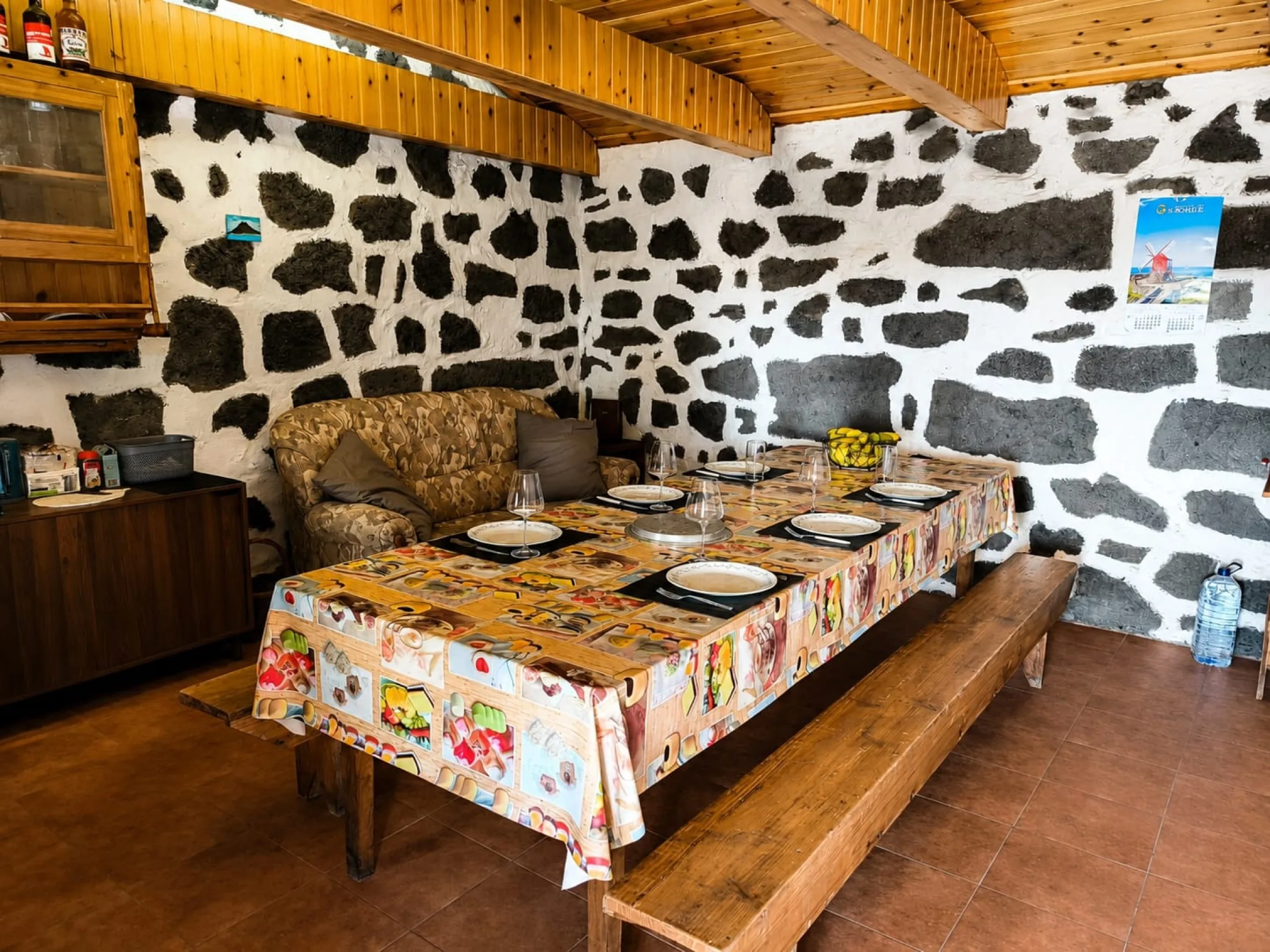 Sala de refeições tradicional com mesa grande e paredes em pedra